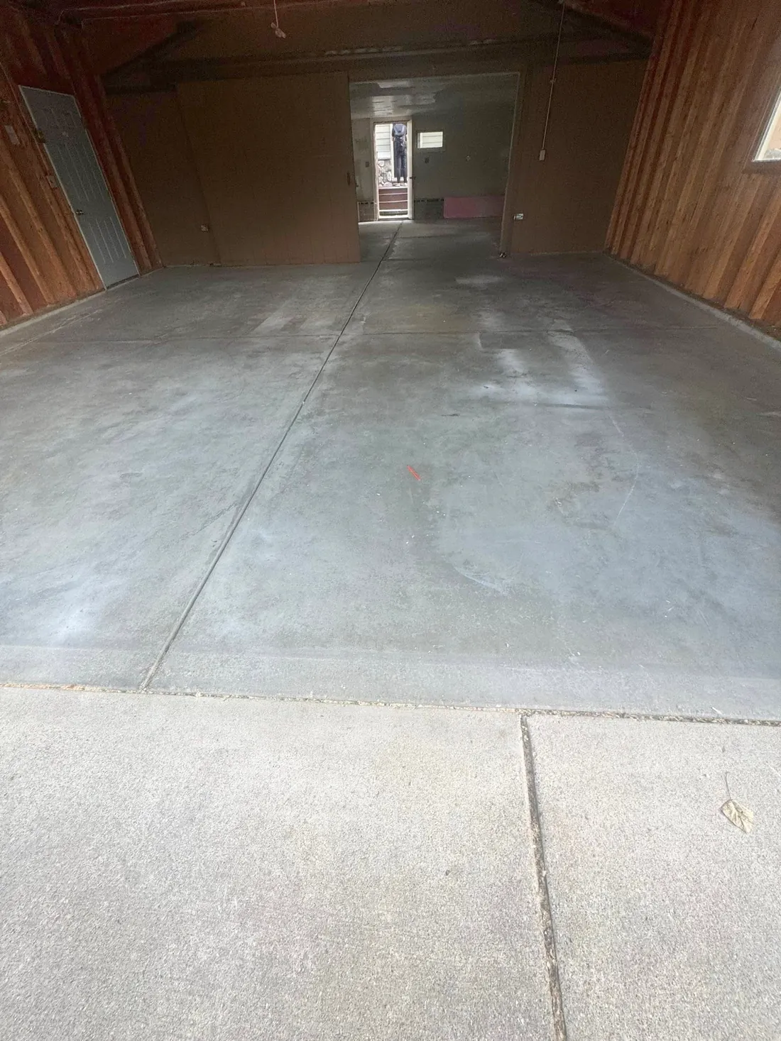 Before: bare concrete garage floor with visible joints and surface marks, wood walls and an open interior doorway.