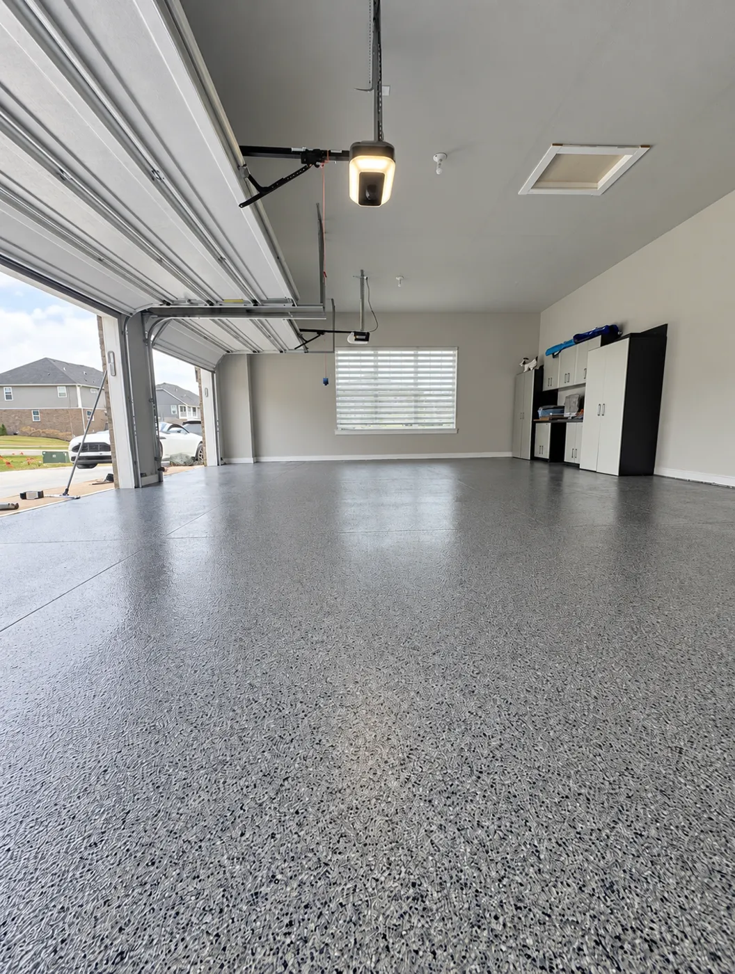 Maximum Painting project: gray flake-coated garage floor with white walls and cabinets.