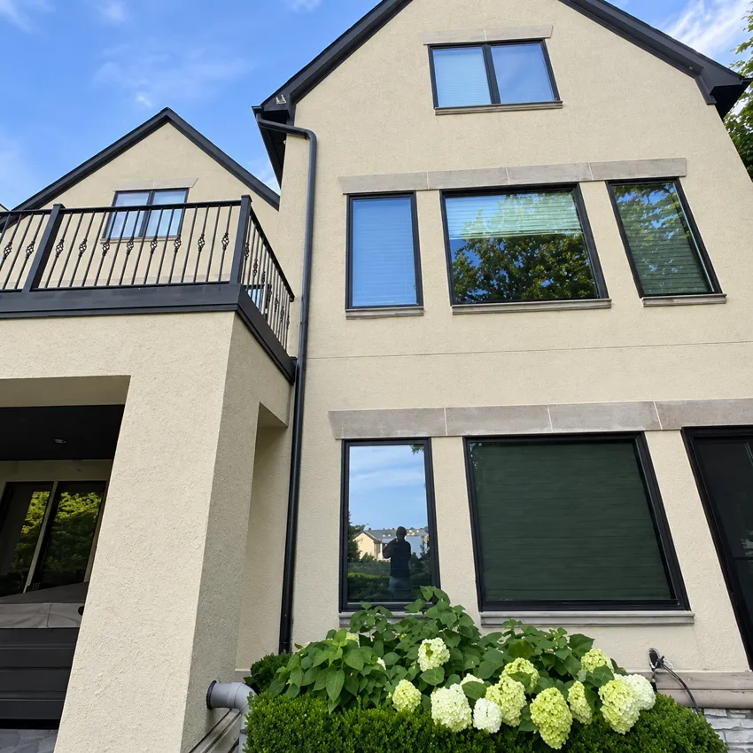 Light-colored multistory home exterior with black-framed windows.