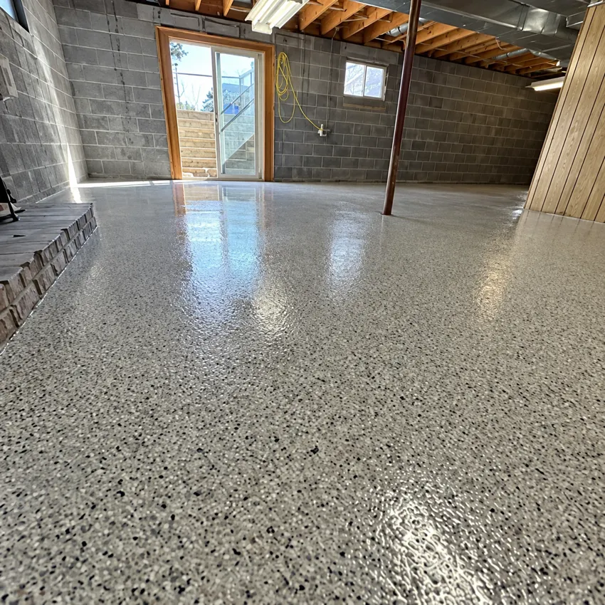 Flake-coated basement floor with existing block walls and exposed ceiling.
